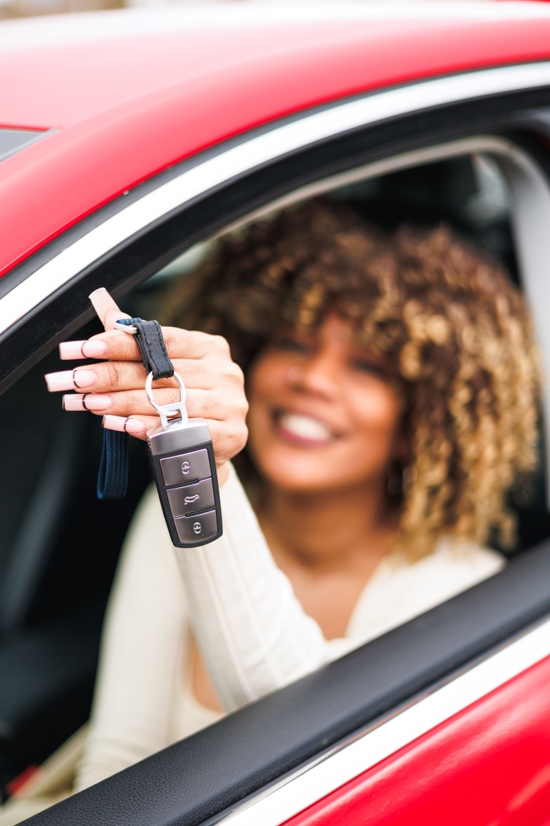 afro-woman-in-red-car-showing-her-new-keys-rentin-2023-11-27-05-25-41-utc