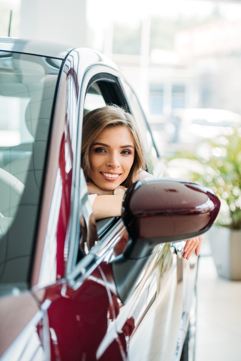 happy-smiling-female-customer-sitting-in-a-red-car-2023-11-27-05-06-20-utc