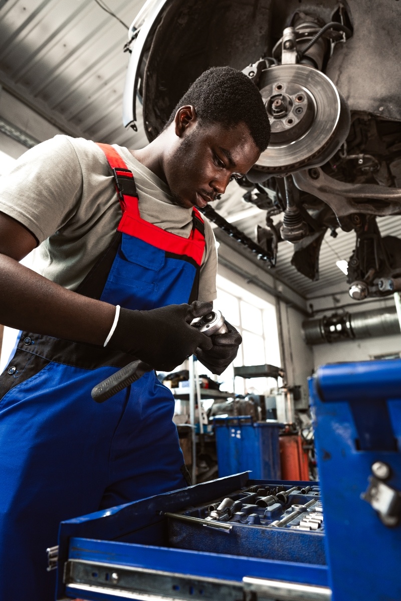 young-african-mechanic-in-uniform-working-in-a-car-2024-01-15-21-26-40-utc